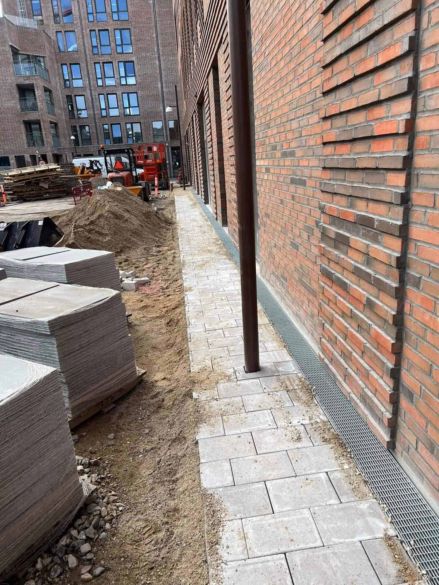 Anlæg af flisesti langs mur af brolægger i Næstved